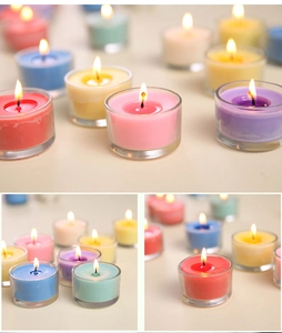 Close-up of assorted colored scented candles in transparent glass jars for home decor