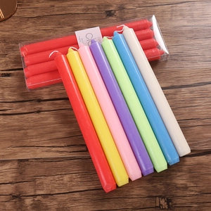 Detailed view of assorted colorful taper candles in red, yellow, and blue on wood