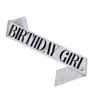 Close-up of sparkling silver glitter sash with bold black Birthday Girl printed text