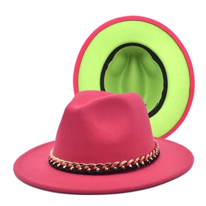 Detail of fedora hat featuring fuchsia exterior, neon green brim and gold chain band