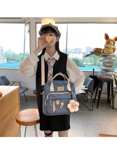 Blue canvas backpack featuring cute plush flower pendant and various cartoon badges