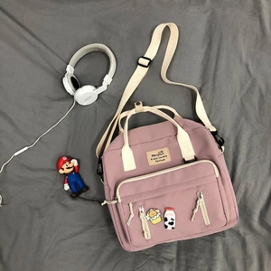 Pink canvas crossbody bag with cute badges and adjustable straps for daily use