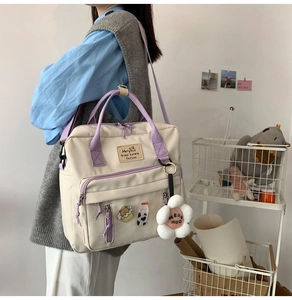 Detail of cream canvas crossbody bag with lilac straps and cute plush floral charms