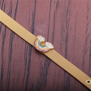 Golden mesh band bracelet featuring a colorful rainbow and cloud zircon charm on wood