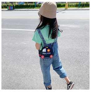 Rear view of a child wearing a cute navy blue police car shaped crossbody bag outdoors