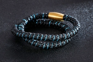 Détail du bracelet en cuir tressé noir avec fil bleu et fermoir magnétique doré