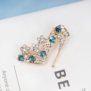 Close-up of gold high heel brooch with blue square rhinestones and floral crystals