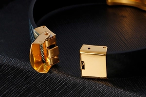 Close-up of gold stainless steel folding clasp and black woven texture on men's bracelet
