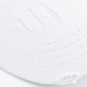 Macro detail of white distressed cotton baseball cap with parallel stitching and frayed edges