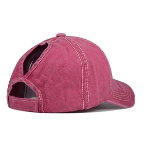 Dettaglio cappellino in cotone magenta con apertura a V per coda di cavallo ed effetto usurato