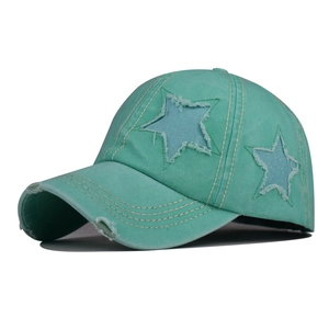 Dettaglio cappellino verde menta con stella glitterata ed eleganti bordi consumati