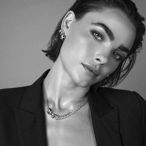 Double-layered silver link chain necklace and hoop earrings on model in black and white