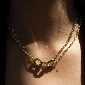 Macro detail of gold-plated double-layer chain necklace with interlocking rings