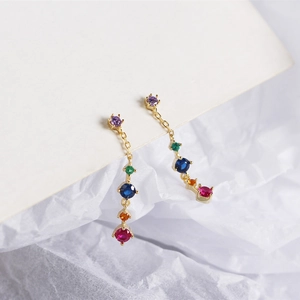 Macro view of long gold fringe earrings featuring vibrant colorful zircon stones