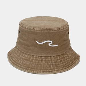 Detailed view of white wave embroidery on a washed khaki canvas bucket hat