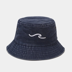 Macro shot of navy washed denim bucket hat with white wave embroidery and metal eyelets