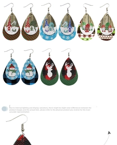 Vue détaillée de boucles d'oreilles en cuir en forme de goutte avec gnomes et bonshommes de neige.