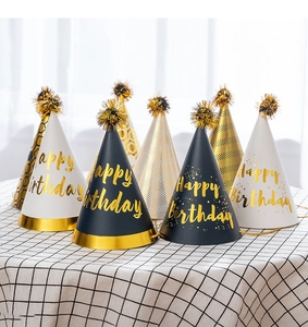 Detail of seven black and gold glitter birthday hats with tassels on a checkered surface