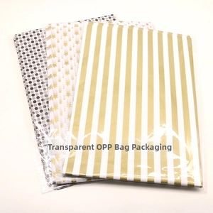 Close-up of gift wrapping tissue paper with gold stars, dots and stripes in OPP bag