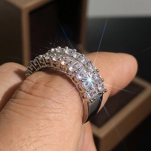Vue macro d'une bague d'éternité luxueuse à trois rangées de zircons au doigt