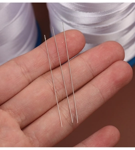 Detailed macro view of three silver Pony beading needles for DIY jewelry and pearl crafts