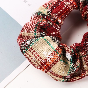 Plaid Christmas scrunchie with white snowflake patterns on red and green fabric