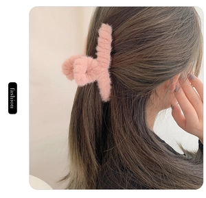 Close-up of pink plush hair claw clip for women showing soft faux fur texture