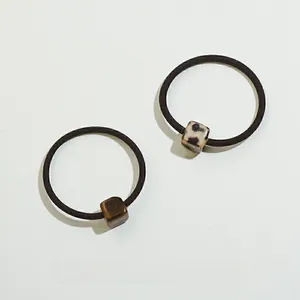 Detail of high-elastic hair ties featuring leopard and tortoiseshell patterned cube beads