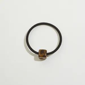 Detail of high-elastic black hair tie featuring a polished leopard print square bead