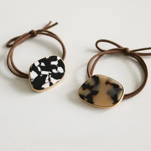 Detail of high-elasticity brown hair ties with elegant tortoiseshell resin accents