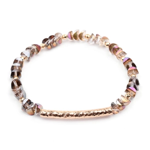 Detail of faceted grey crystal beads and a hammered gold-tone curved tube on the bracelet