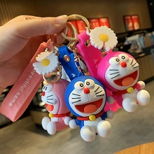 Primo piano di portachiavi Doraemon in silicone rosa e blu con ciondoli a margherita e cinturini