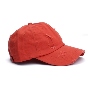 Distressed orange cotton baseball cap with vintage frayed holes and a retro street style