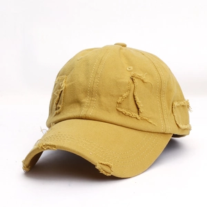 Distressed mustard yellow cotton baseball cap with vintage frayed holes and worn-out details