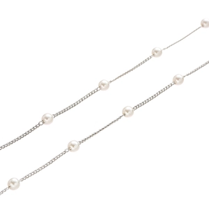 Detail of elegant silver eyewear chain with round white pearls on minimalist thin metal link