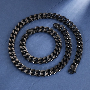 Gros plan sur l'ensemble collier et bracelet à mailles gourmette noir mat sur fond bleu