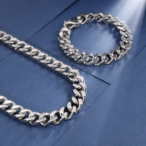 Gros plan d'un ensemble collier et bracelet gourmette en acier inoxydable poli argenté