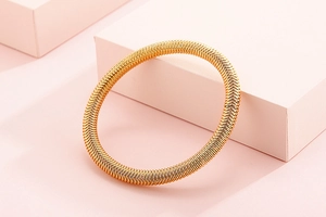 Detailed view of a gold-tone spring spiral bangle with a sleek metallic finish