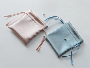 Detail of pink and blue satin drawstring pouches for jewelry storage and gift packaging