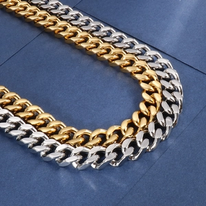 Close-up of polished gold and silver Cuban link chains showing dense metal texture