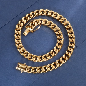 Macro shot of thick gold-plated Cuban link chain with polished finish on a blue backdrop