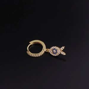 Close-up of gold huggie hoop earring with blue and clear zircon fish pendant