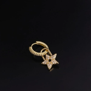 Detailed view of a gold star earring with sparkling cubic zirconia on black background