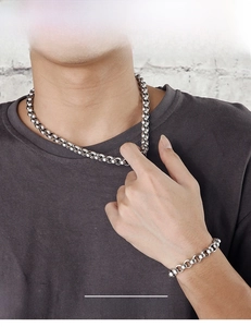 Close-up of men's chunky titanium steel chain necklace and matching bracelet set