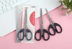 Close-up of black handle stainless steel office scissors with blister card packaging