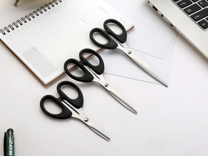 Three sizes of black stainless steel scissors set shown on a professional office desk
