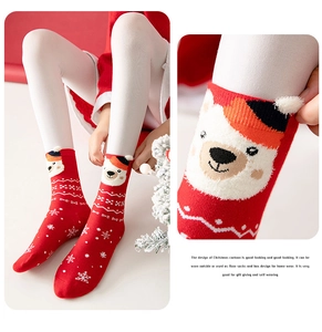 Macro detail of red festive Christmas socks with 3D cartoon bear and snowflake patterns