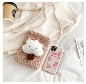 Detail of soft plush cloud crossbody bag in pink and white with a woven shoulder strap