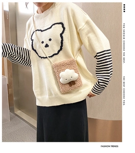 Detail of white knit sweater with bear motif and plush cloud shoulder bag in soft brown