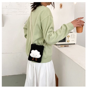 Detail of a cute black plush phone bag featuring a soft white cloud character with 3D legs